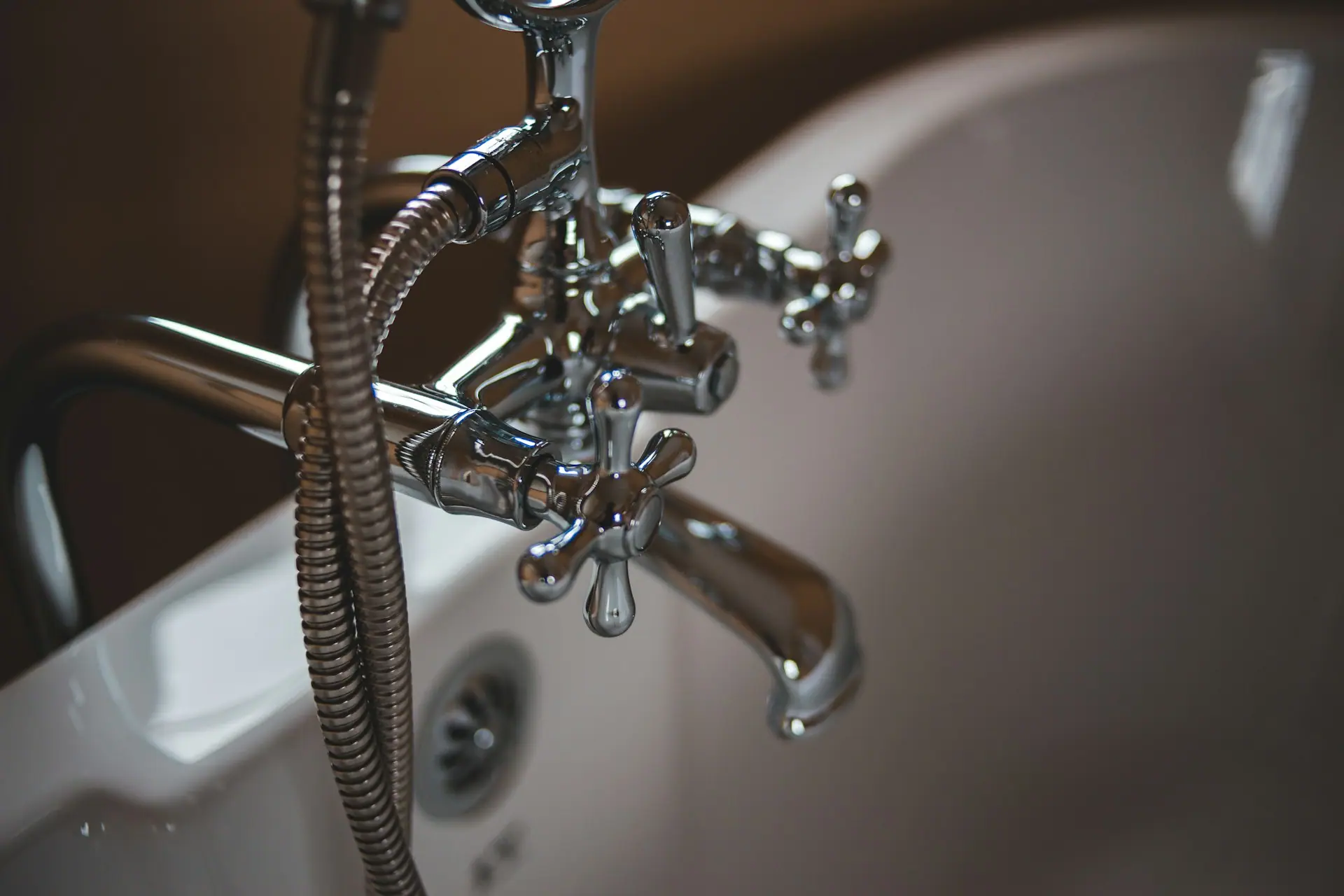 Close-up of a chrome mixer tap and shower hose